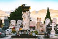 Panoramic view on tombstones at cemetery. stone sculpture with flowers in an old cemetery. Closeup of stoned angel and cross monum