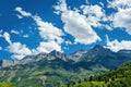 A panoramic view of towering mountains against a brilliant blue sky epitomizes summer beauty