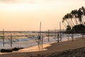 Panoramic view on traditional fishermen stilt sticks for fishing in the ocean wavesat sunset near Mirissa, Ahangama, Sri