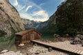 Panoramic view traditional old wooden boat house at scenic Lake Obersee on a beautiful day with foggy clouds in autumn, Bavaria, Royalty Free Stock Photo