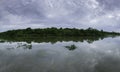 Panoramic view of trees and clouds reflecting on glassy lake Royalty Free Stock Photo