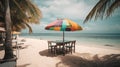 Panoramic view of two wooden chairs, table and a multi-colored saloma umbrella on the beach. Sea with turquoise water Royalty Free Stock Photo