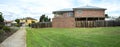 Panoramic view of a vacant land next to a two-story residential house. Royalty Free Stock Photo