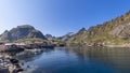 Panoramic view from the water featuring classic red wooden Rorbu houses on the rocky shores of Moskenes