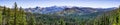 Panoramic view of wilderness areas in Yosemite National Park with evergreen forests covering valleys and snow capped mountains Royalty Free Stock Photo