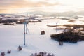 Panoramic view of wind turbines standing in the winter field at sunset