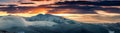 Panoramic view of winter mountains at sunrise. Landscape with foggy hills and trees covered with rime. Royalty Free Stock Photo