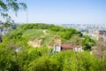 Panoramic view of the Zamkova Hora Castle Hill or mount in Kyiv covered with greenery. In the background cityscape of Podil and