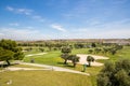 Panoramic views of golf course with sandpit, lake, trees and buggies Royalty Free Stock Photo