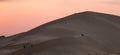 Panoramic view of people climbing the huge sand dunes in Badr, Medina, in Saudi Arabia at sunset Royalty Free Stock Photo