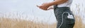 Panoramic Web Banner Power Bank In The Back Pocket Of A Girl In A Yellow Field Charges The Phone