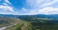 Panoramic wide banner view of a Chike-Taman pass in the Altai mountains with green trees, Blue sky and clouds Royalty Free Stock Photo