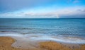 Winter view of Baltic sea with beach and rainbow over maritime horizon offshore Gdynia Orlowo district of Tricity in Poland