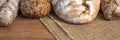 Panoramic wooden kitchen top with bread and rolls on a jute bag Royalty Free Stock Photo