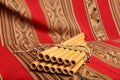 Panpipes from South America sitting against a red textile