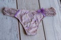 thong underpants on a wooden background. Panties pink for women