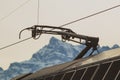 Pantoghraph, the device to pick up current from overhead lines on swiss railways. Visible mountains in switzerland in the Royalty Free Stock Photo