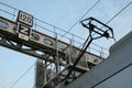 Pantograph of French railways train captating electricty from a catenary overhead line on a railroad infrastructure with train