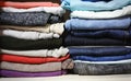 Pants of different colors stacked in a closet