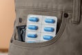 Pants with pills and condom in pocket, closeup. Potency problem Royalty Free Stock Photo