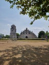 Paoay church surrounded by lush green trees and sandy terrain Royalty Free Stock Photo