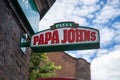 A Papa Johns logo sign outside a restaurant in London