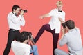 Paparazzi taking photographs of male actor over red background Royalty Free Stock Photo