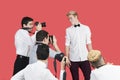 Paparazzi taking photographs of male actor over red background Royalty Free Stock Photo