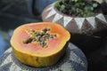 Papaya cut in half with seeds in a flower pot