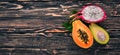 Papaya, Dragon Fruit, Cactus Fruit. Fresh Tropical Fruits. On a wooden background.