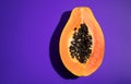 Papaya fruit on bright violet background. Half of fresh organic Papaya exotic fruit close up. Top view