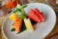 Papaya, pineapple, melon and watermelon, orange with lime and mint on a white plate on the table. Summer fruit lunch Royalty Free Stock Photo