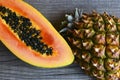 Papaya and pineapple tropical fruits cut in half on old wooden table.Healthy raw food,diet or vegan meal concept. Royalty Free Stock Photo