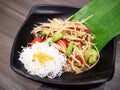 Papaya Salad with Salted Crab and Fermented Fish with Rice Noodles, serving on black plate Royalty Free Stock Photo