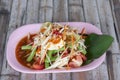 Papaya salad and Salted egg in pink plate Thai people call Som Tam Thai Kai Khem. Royalty Free Stock Photo