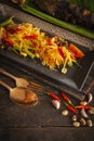 Papaya Salad Som tum Thai on square black plate placed on the wood table there are bean, grilled fish, garlic, chilli spoon and Royalty Free Stock Photo