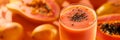 Papaya smoothie banner, orange background, close up, copy space. Smooth papaya smoothie garnished with fresh mint and seeds. Royalty Free Stock Photo