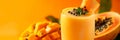 Papaya smoothie banner, yellow background, close up, copy space. Smooth papaya smoothie garnished with fresh mint and seeds. Royalty Free Stock Photo