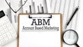 Paper with ABM Account Based Marketing on table with charts