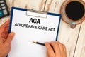 Paper with ACA Affordable Care Act on the table  calculator and cup of coffee Royalty Free Stock Photo