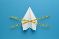 Paper airplane on blue background under quarantine. Cancellation of flights of civil and touristic aviation. Crisis of air travel Royalty Free Stock Photo