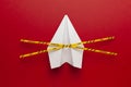 Paper airplane on red background under quarantine. Cancellation of flights of civil and touristic aviation. Crisis of air travel Royalty Free Stock Photo