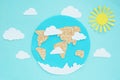 Paper application: planet Earth, continents, clouds, and the sun on a blue background. Royalty Free Stock Photo