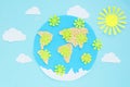 paper application: planet earth, continents, clouds, sun and green viruses around on a blue background. Coronavirus pandemic