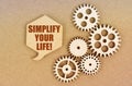 On a paper background, gears and a thought plate with the inscription - Simplify Your Life