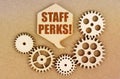 On a paper background, gears and a thought plate with the inscription - Staff Perks