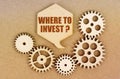On a paper background, gears and a thought plate with the inscription - Where To Invest Royalty Free Stock Photo