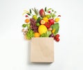 Paper bag with assortment of fresh organic fruits and vegetables on white background, top view Royalty Free Stock Photo