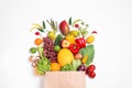 Paper bag with assortment of fresh organic fruits and vegetables on white background, top view Royalty Free Stock Photo