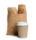 Paper bag with bread and cup of coffee on white background. Royalty Free Stock Photo